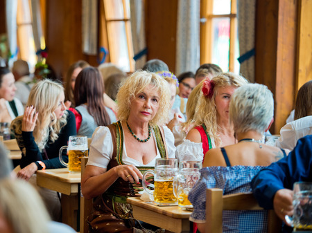 Munich, Germany - October 07, 2018: Woman drinking beer in beer pavilion at the biggest folk festival in the world - the oktoberfest.のeditorial素材