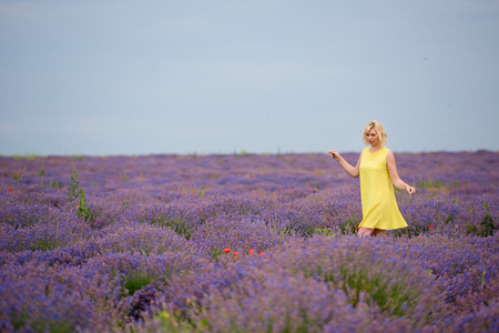 Young girl in yellow dress, posing in a lavender field.の写真素材