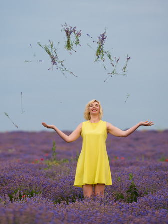 Young girl in yellow dress, posing in a lavender field.の写真素材