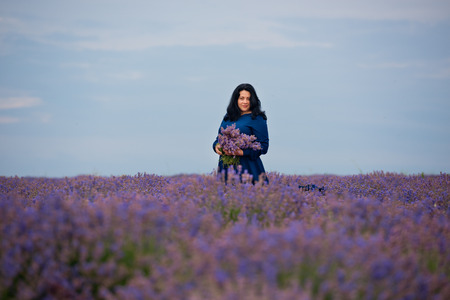 Young girl in blue dress, posing in a lavender field.の写真素材