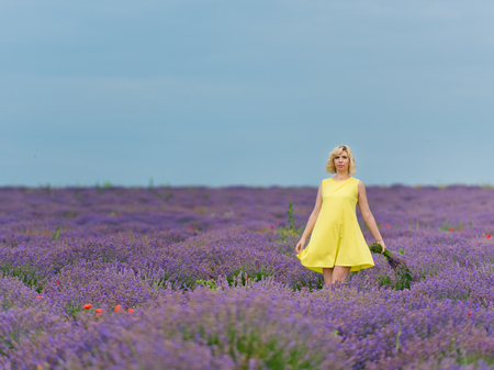 Young girl in yellow dress, posing in a lavender field.の写真素材