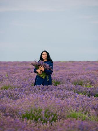 Young girl in blue dress, posing in a lavender field.の写真素材