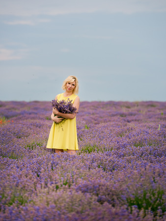 Young girl in yellow dress, posing in a lavender field.の写真素材