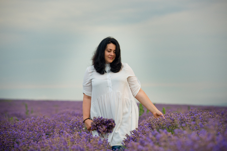Young girl in white dress, posing in a lavender field.の写真素材