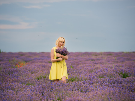 Young girl in yellow dress, posing in a lavender field.の写真素材