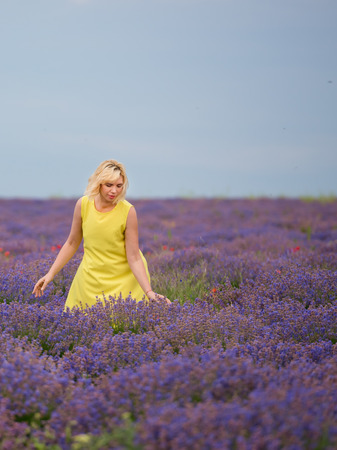 Young girl in yellow dress, posing in a lavender field.の写真素材
