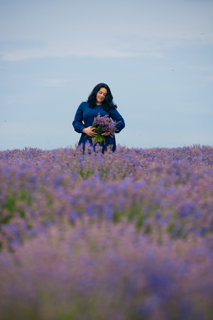 Young girl in blue dress, posing in a lavender field.の写真素材