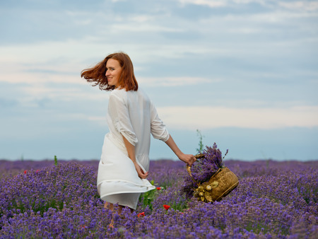 Young girl in white dress, posing in a lavender field.の写真素材
