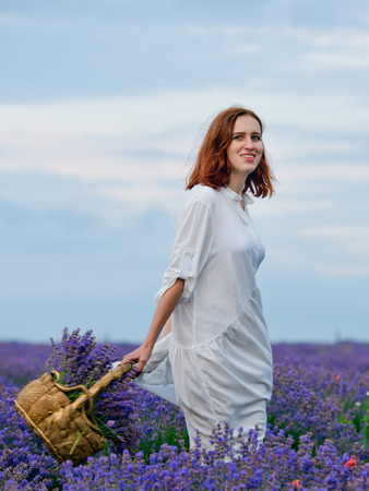 Young girl in white dress, posing in a lavender field.の写真素材