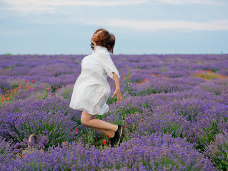 Young girl in white dress, posing in a lavender field.の写真素材