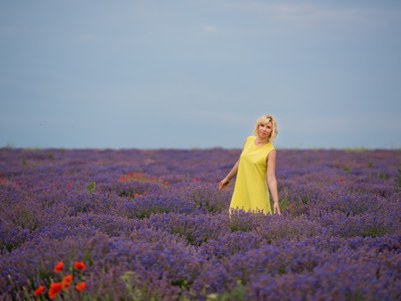 Young girl in yellow dress, posing in a lavender field.の写真素材