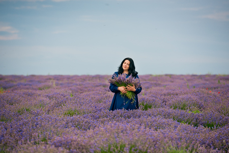 Young girl in blue dress, posing in a lavender field.の写真素材