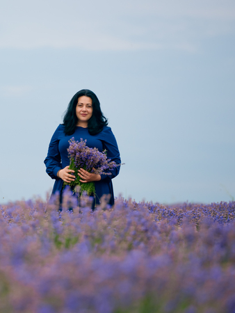 Young girl in blue dress, posing in a lavender field.の写真素材