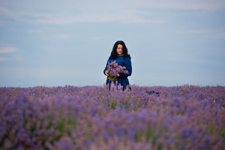 Young girl in blue dress, posing in a lavender field.の写真素材
