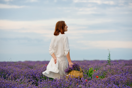 Young girl in white dress, posing in a lavender field.の写真素材