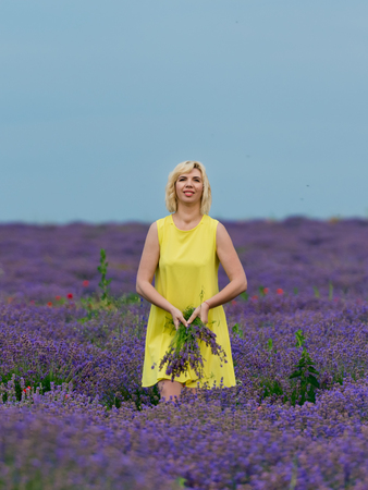 Young girl in yellow dress, posing in a lavender field.の写真素材