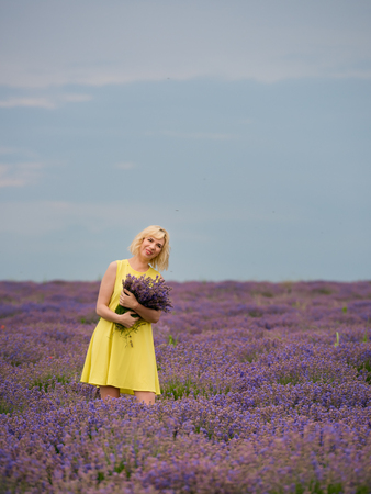 Young girl in yellow dress, posing in a lavender field.の写真素材