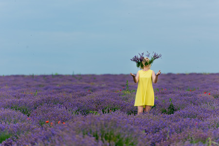 Young girl in yellow dress, posing in a lavender field.の写真素材