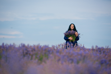 Young girl in blue dress, posing in a lavender field.の写真素材