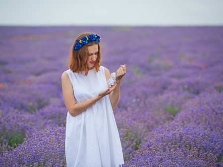 Young girl in white dress, posing in a lavender field.の写真素材