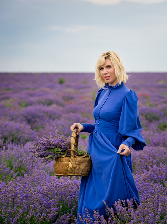Young girl in blue dress, posing in a lavender field.の写真素材