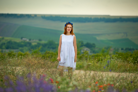 Young girl in white dress, posing in a lavender field.の写真素材