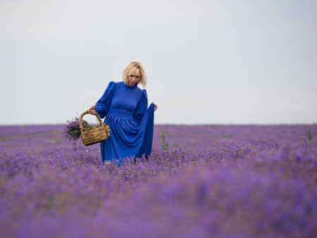 Young girl in blue dress, posing in a lavender field.の写真素材