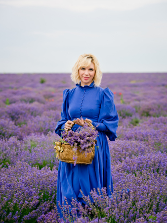 Young girl in blue dress, posing in a lavender field.の写真素材