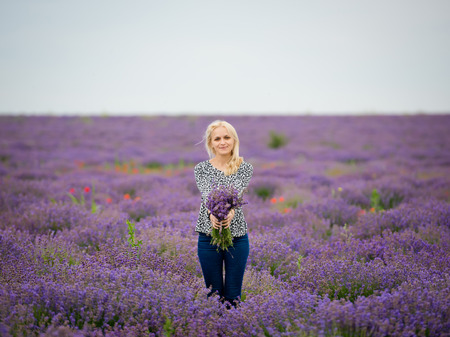 Soft focus flowers, beautiful lavender flowers blooming. Cute girl with a bouquet of lavender flowers.の写真素材