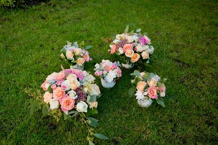 Five different wedding bouquets on a green grass.の写真素材
