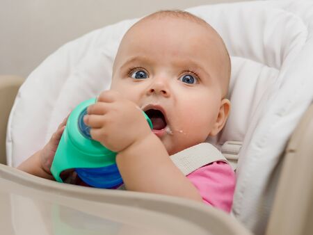 Baby drinks water from a bottle.の写真素材