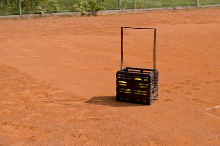 Basket for tennis balls on the court.の写真素材