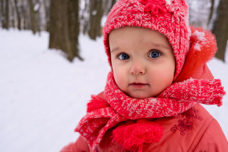 Baby girl impressed with the snow. Close-up.の写真素材