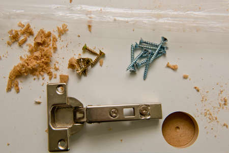Installation of metal hinges to the chipboard. Selective focus. Close up.の写真素材