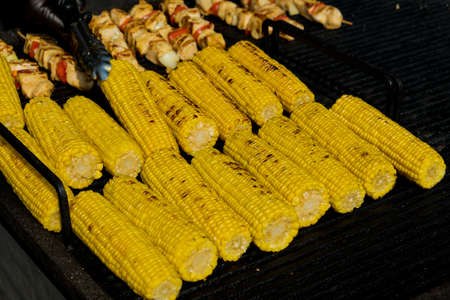Grilling corn cob. Street food festival. Selective focus.の写真素材