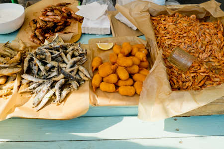 Various fried seafood on the counter ready to eat. Street food festival. Selective focus.の写真素材