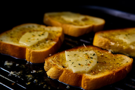 Garlic paste on toasted bread slices. Closeup.の素材