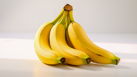 Bunches of bananas sitting next to each other on white surface.の素材
