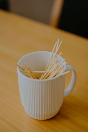 A white cup filled with wooden chopsticksの素材