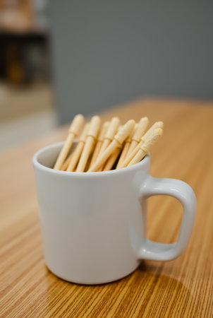 A white cup filled with wooden toothpicksの素材