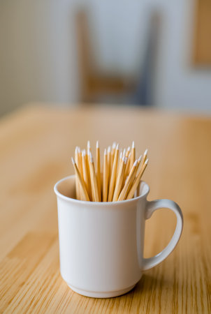 A white cup filled with yellow pencilsの素材