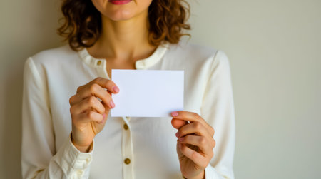 A woman holding a blank white cardの素材