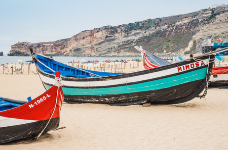Old traditional wooden fishing boats on the beach of Nazaré, Portugal.の写真素材