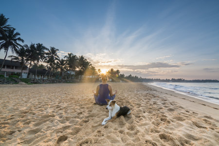 Young Woman Practicing Yoga on the Beach During Sunrise in Hikkaduwa, Sri Lankaの写真素材