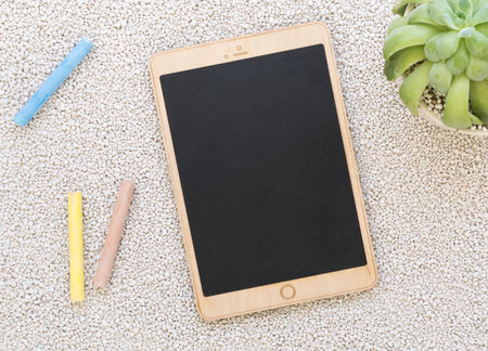 Tablet shaped chalk board on white pebbles backgroundの写真素材