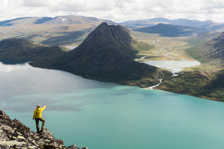 Girl standing on Besseggen ridge overlooking Gjende and Ovre Leirungen lakes, Norwayの写真素材