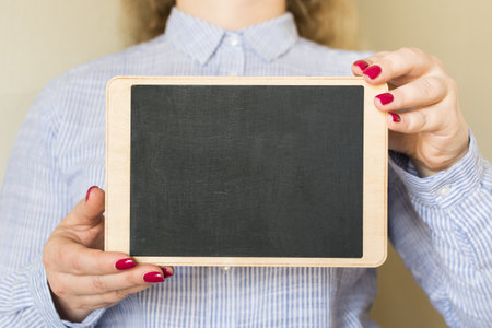 Young woman holding a chalk board in her handsの写真素材