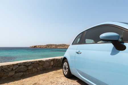 Light blue rental car parked next to the sea in Mykonos island, Greeceの写真素材