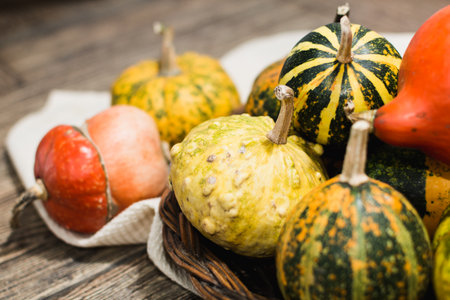 Basket with decorative pumpkins on dark wood background.の写真素材
