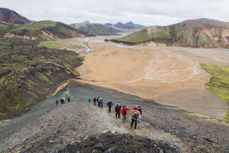 LANDMANNALAUGAR, ICELAND - AUGUST 2018: Tourists trekking in the colourful mountains of Landmannalaugar national park.のeditorial素材